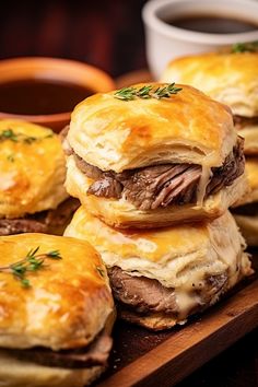 small sandwiches with meat and cheese are on a wooden tray