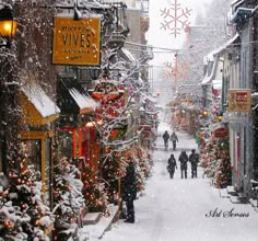 people walk down a snowy street lined with shops