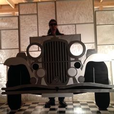 a person standing behind a car made out of cardboard