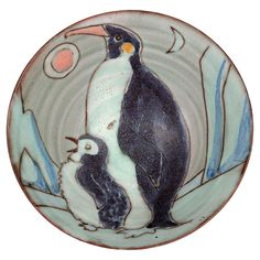 a ceramic plate with two penguins on it