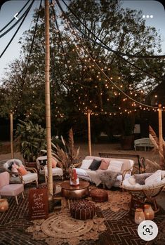 an outdoor seating area is decorated with lights and wicker furniture, including two sofas