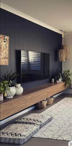 a living room filled with furniture and a flat screen tv on top of a wooden shelf