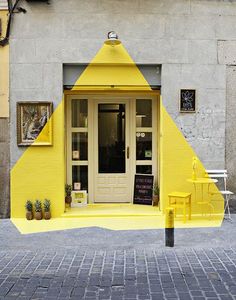 a yellow building with an open door on the outside