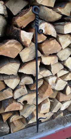 a large pile of wood sitting next to a metal hook