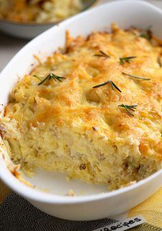 a close up of a casserole in a white dish on a yellow table cloth