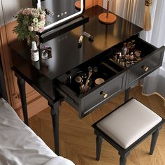 a black vanity table with drawers and stools