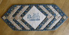 blue and white quilted placemats sitting on top of a wooden table