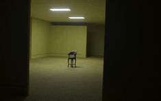 a chair sitting in an empty room with lights on the ceiling and floor below it