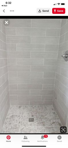 a walk in shower sitting next to a white tiled wall and floor covered in gray tile