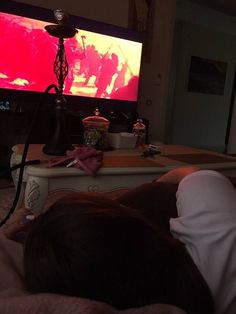 a person laying down in front of a flat screen tv