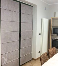 a kitchen with a table and chairs next to a sliding glass door that has blinds on it