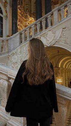 a woman in black jacket walking down stairs