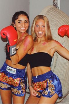 two women wearing boxing gloves pose for a photo