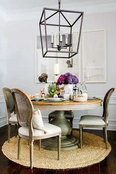 a dining room table with chairs around it and a chandelier hanging from the ceiling