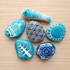 five painted rocks sitting on top of a wooden table