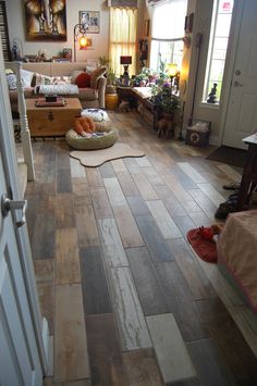 a living room filled with furniture and lots of wood flooring on top of it