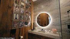 there is a bathroom with pictures on the wall and a round mirror in the corner