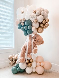 a teddy bear sitting on top of balloons