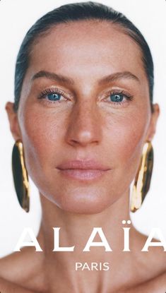 a woman with blue eyes and large gold hoop earrings on her head is featured in the cover of an article