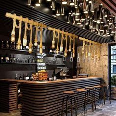 a bar with lots of lights hanging from it's ceiling and some chairs in front of it