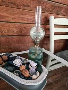 a glass vase sitting on top of a table next to a container filled with rocks