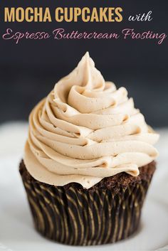 a chocolate cupcake with frosting on a white plate, ready to be eaten