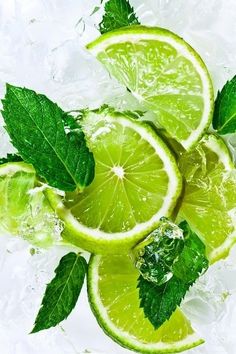 limes with leaves and water splashing on them