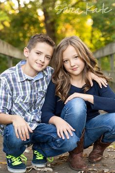 two children posing for a photo in the fall