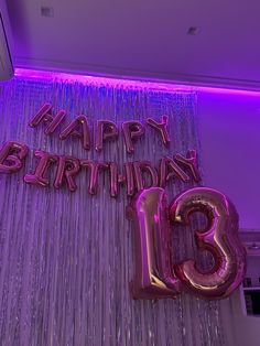 the number thirteen is lit up with purple lights and streamers for a 13th birthday party