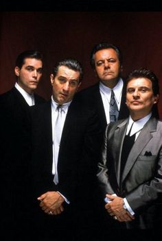 four men in suits and ties posing for the camera