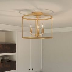 a light fixture hanging from the ceiling in a room with white cabinets and cupboards