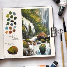 an artist's notebook with watercolors and paints