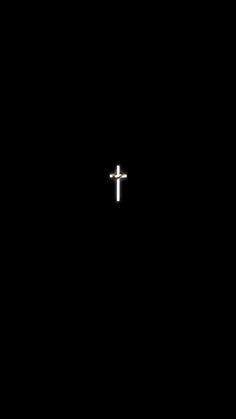 a cross is seen in the dark with only one light on at the end of it