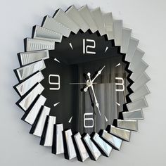 a clock that is on the wall and has many mirrors around it's face