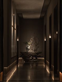 the hallway is dimly lit by two lamps and a vase with flowers in it sits on an end table