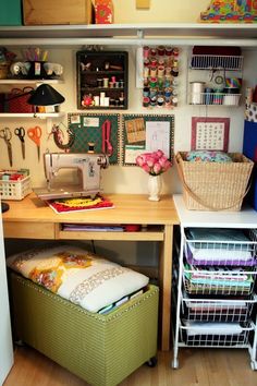 a sewing room with lots of crafting supplies on the desk and storage bins