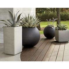 three planters sitting on top of a wooden table