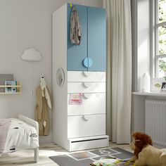 a child's bedroom with a white and blue dresser next to a teddy bear