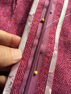 someone is stitching something on the fabric with their fingers and needle to make it look like they're sewing