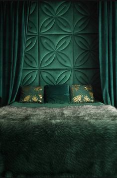 a bedroom with green velvet walls and gold pillows