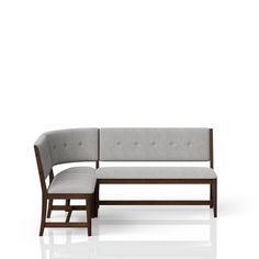 a gray couch sitting on top of a white floor next to a wooden frame bench