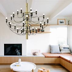 a living room filled with furniture and a large chandelier hanging from the ceiling