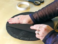 a woman's hand on top of a black hat