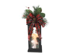 a candle with a red and black plaid bow on it is sitting in a lantern