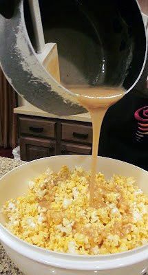 a woman pours orange juice into a bowl of popcorn