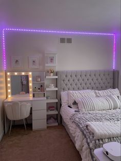 a bedroom with lights on the wall and a bed in front of a mirror that has an illuminated headboard