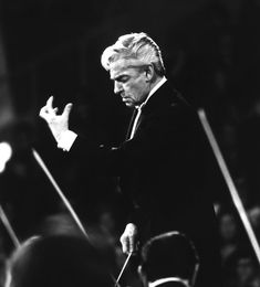 the conductor is directing an orchestra in black and white