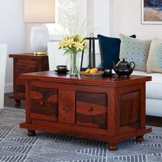 a living room with a couch, coffee table and two vases on top of it