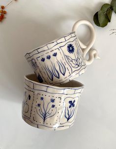 two blue and white cups sitting on top of each other