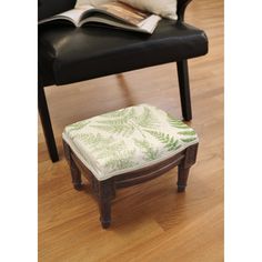 a black chair with a blue and white footstool sitting on a hard wood floor